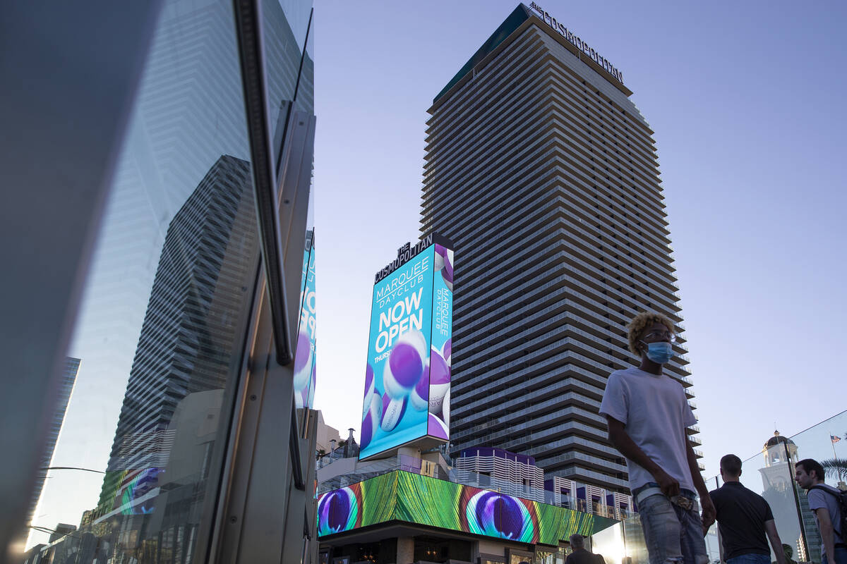 Besökare på Las Vegas Strip korsar en gångbro utanför Cosmopolitan of Las Vegas på ...