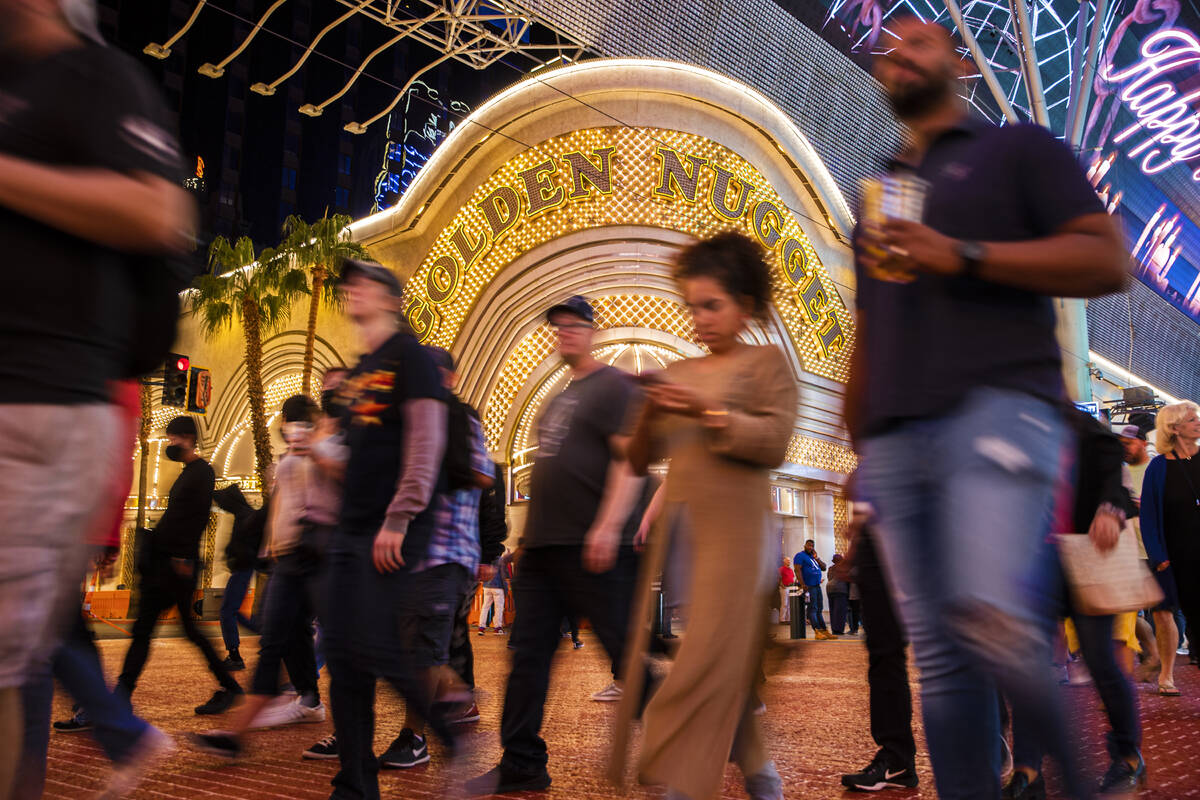 Människor går förbi The Golden Nugget på Fremont Street onsdagen den 20 oktober 2021 i Las Vegas. ...